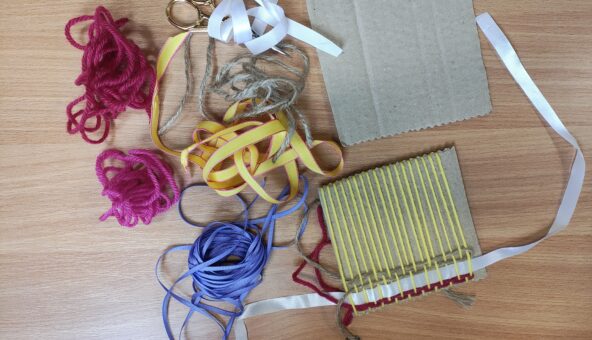 Table with craft materials, including wool and paper.