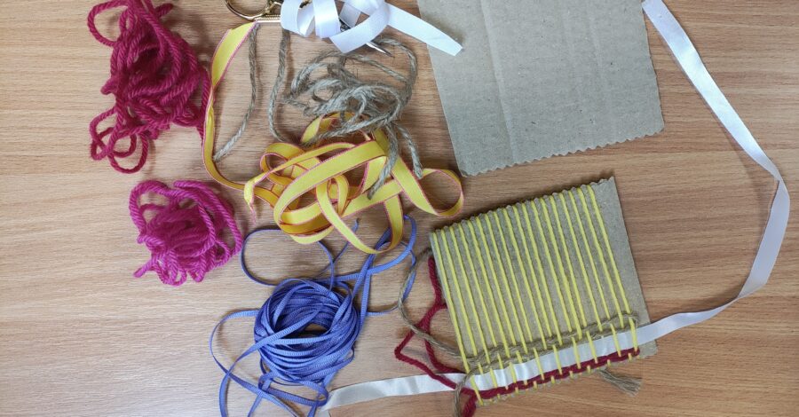 Table with craft materials, including wool and paper.