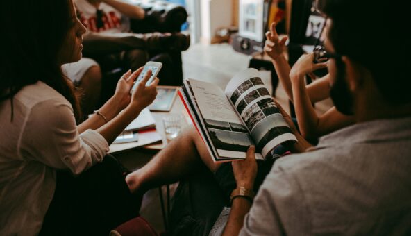 A group of people sitting on chairs reading books and sharing.