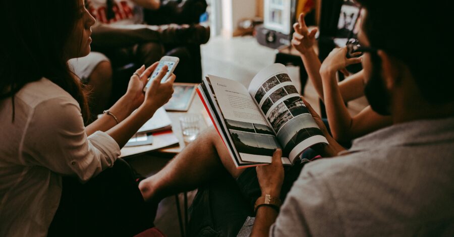 A group of people sitting on chairs reading books and sharing.