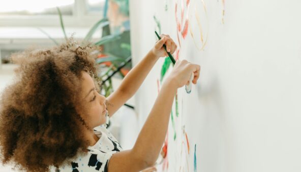 A child paints on a large canvas.
