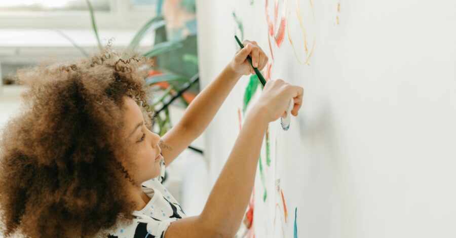 A child paints on a large canvas.