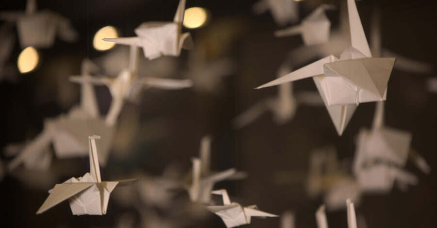 Paper cranes hanging within a case in the Living Worlds gallery at Manchester Museum.