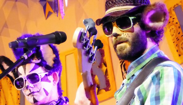 A close-up of two members of Rockin' Rhinos playing their musical instruments on stage.