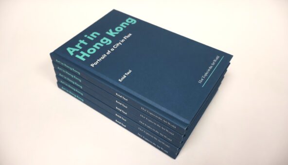 A stack of six hardcover books with dark blue covers titled Art in Hong Kong: Portrait of a City in Flux by Enid Tsui. The text on the cover and spine is printed in teal and white. The books are neatly stacked on a light-colored surface.