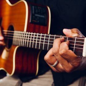 close up of a person playing an acoustic guitar