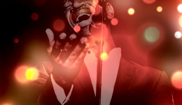 A gospel singer performing with different coloured Christmas lights around him.