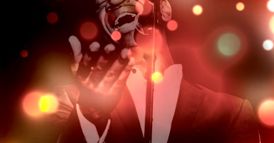 A gospel singer performing with different coloured Christmas lights around him.