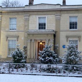 The outside of a historic house covered in snow.