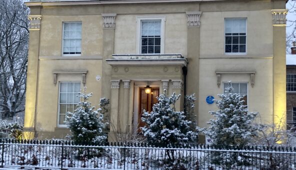 The outside of a historic house covered in snow.