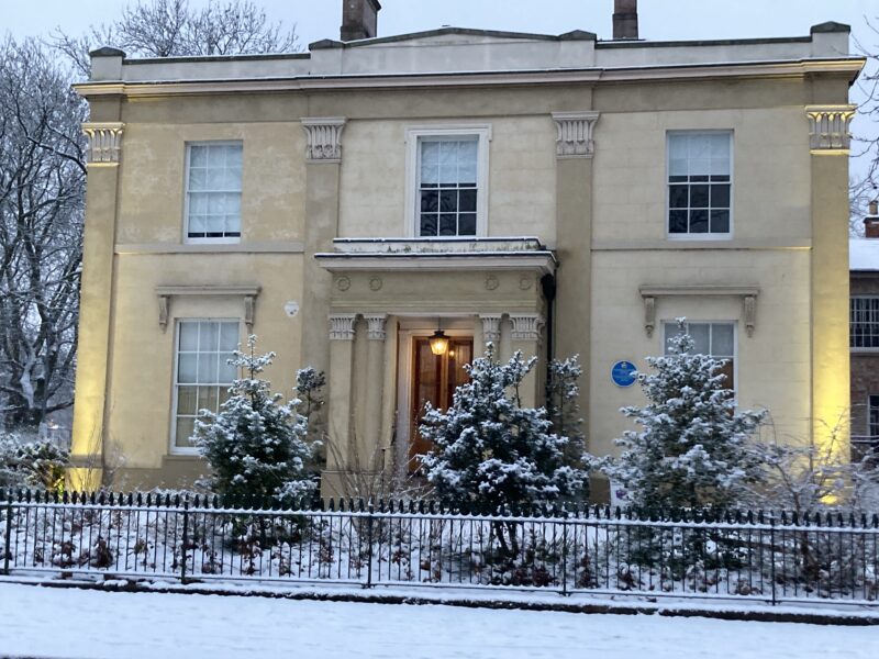 The outside of a historic house covered in snow.