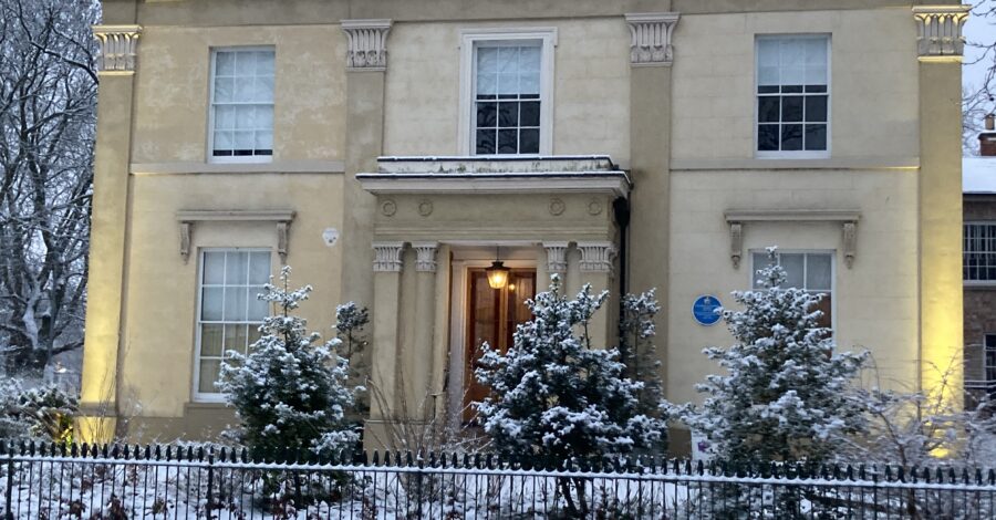 The outside of a historic house covered in snow.
