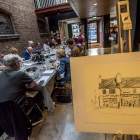 People sitting at a long table and dining.