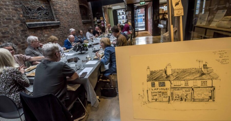 People sitting at a long table and dining.