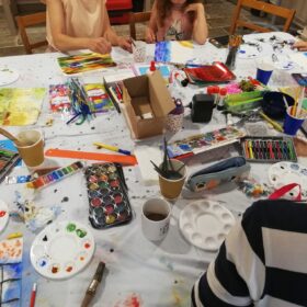 A craft table with children sat round it.