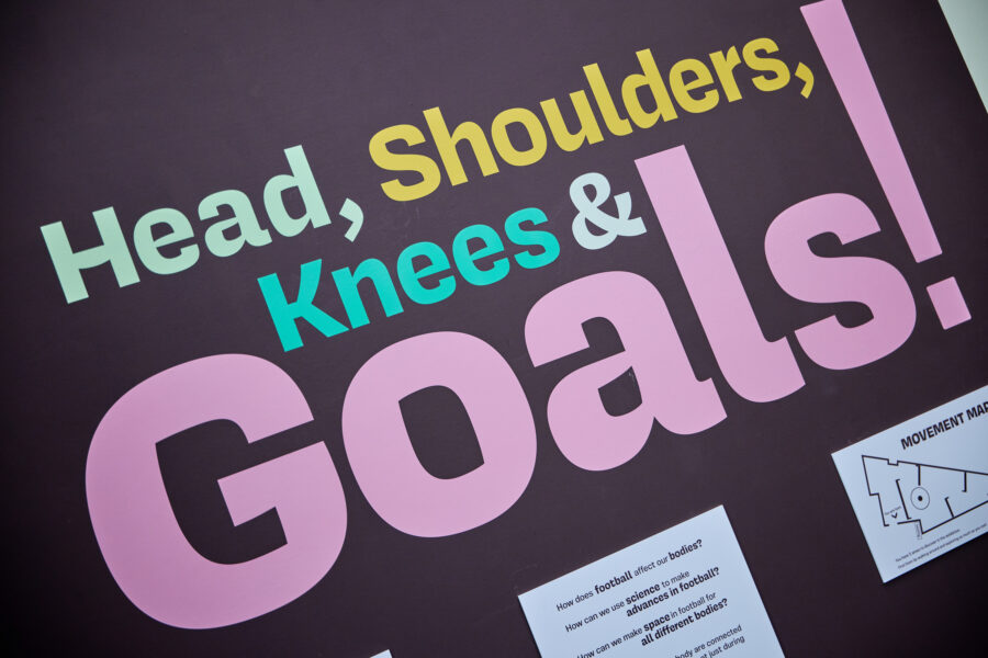 A promotional banner for the show that reads Head, Shoulders, Knees and Goals.