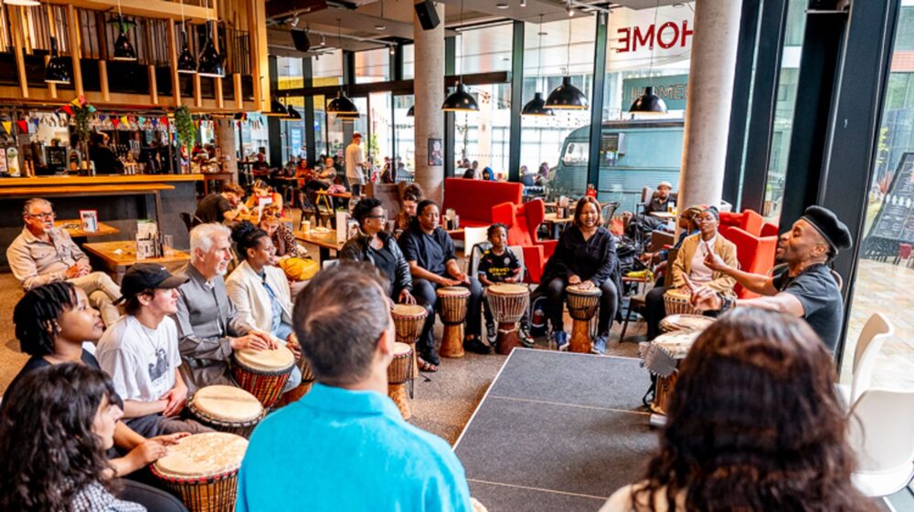 A group of people sat on chairs playing drums.