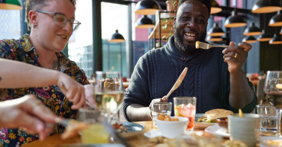 Two people sat at a table enjoying dinner together.