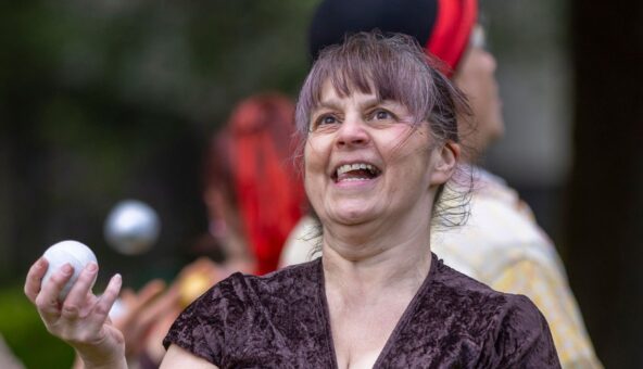 A close-up picture of a person concentrating as they are juggling.