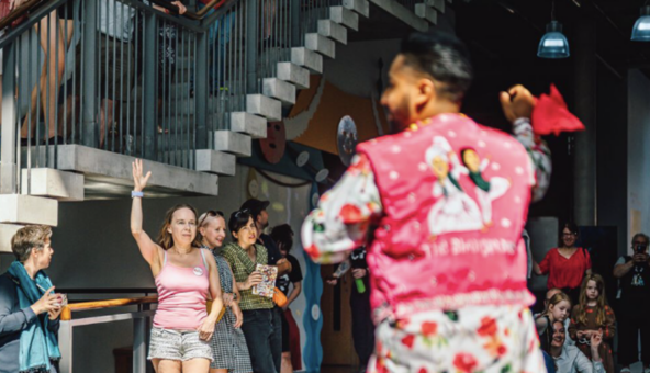 A dancer wearing traditional Bhangra dress teaching a small group to dance.