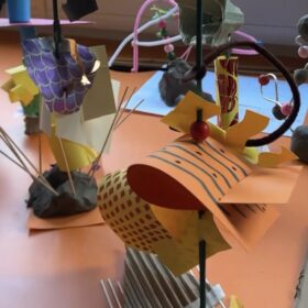 A table with various paper craft artworks displayed on it.