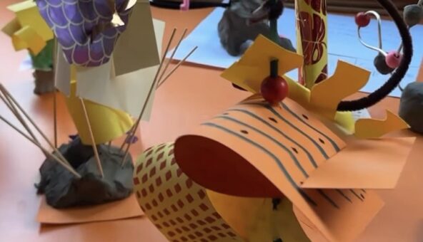 A table with various paper craft artworks displayed on it.