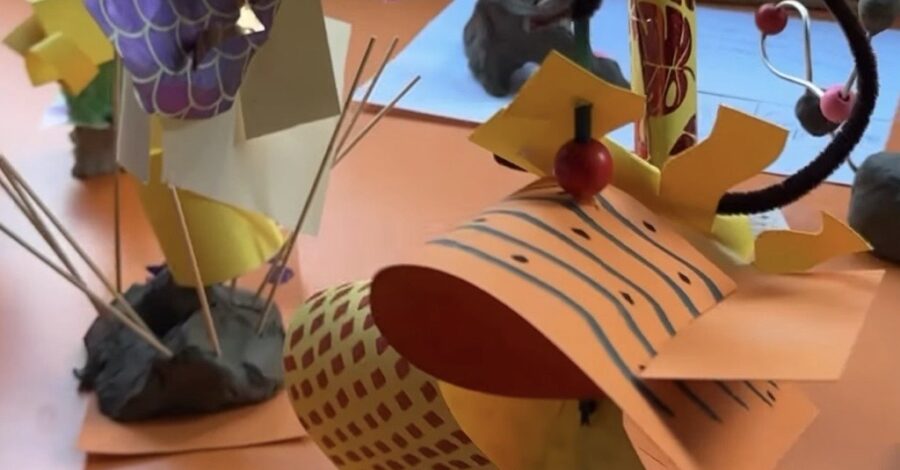 A table with various paper craft artworks displayed on it.