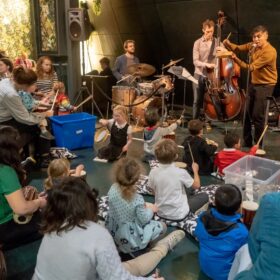 Musicians play to a crowd of people of all ages.