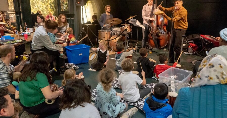 Musicians play to a crowd of people of all ages.